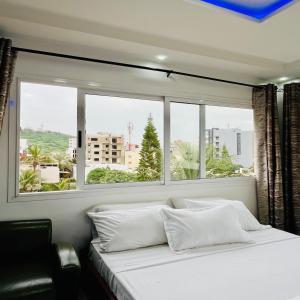 ダカールにあるHôtel Darou Khoudossの大きな白いベッドと窓のある寝室