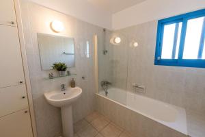 a white bathroom with a sink and a tub and a sink at Beachfront Mediterranean Escape 3bd Sea View Apartment in Pendakomo +41 photos
