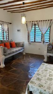 een woonkamer met banken in een kamer met ramen bij villa luna in Watamu