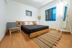 a bedroom with a bed and a chair in it at Beachfront Mediterranean Escape 3bd Sea View Apartment in Pendakomo