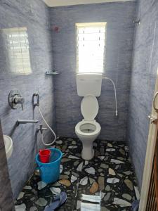 a bathroom with a toilet and a sink and a window at Hotel Seven Heaven in mayapur