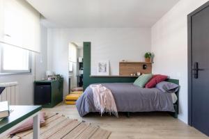 a bedroom with a bed with a green headboard at Residencia Universitaria Resa Campo Grande in Valladolid