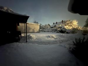 a yard covered in snow next to a house at Ferienhaus Silke in Knittelfeld +35 photos