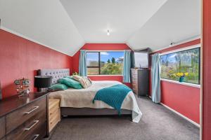 1 dormitorio con paredes rojas, 1 cama y ventana en The Keys To Kinloch!, en Kinloch 5 fotos más