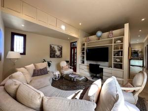 un salon avec des canapés et une télévision à écran plat dans l'établissement Lux 2-Level Townhouse with Stunning Historic Views, à Sans Souci