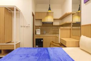 a small kitchen with a blue bed in a room at TwoSpaces Living at Bunda Nana Residence, Gianyar in Gianyar