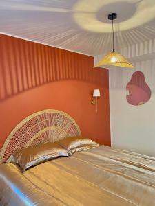 a bedroom with a bed with an orange wall at L escapade dorée in Saulieu