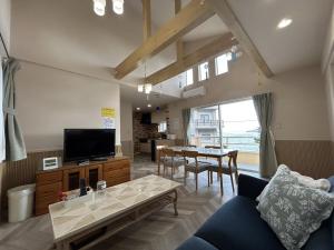 ein Wohnzimmer mit Sofa und Tisch in der Unterkunft 南欧風のゴージャスなオーシャンビラ オーシャンビュー 1棟貸切 バーベキュー 長期滞在 ファミーユ伊豆高原 in Ito