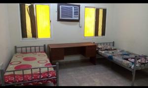 Camera con 2 letti, scrivania e finestre. di Muscat Women's Hostel a Mascate 1 altra foto