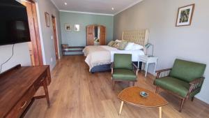 Una habitación de hotel con una cama y dos sillas. en The Royal Hilltop, en Riebeek-Kasteel