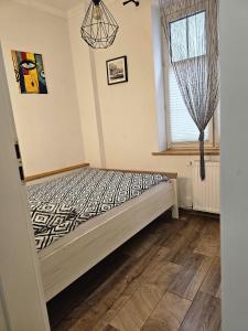 una cama en una habitación con ventana en Theatr City Centre, en Zielona Góra
