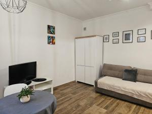 Una sala de estar con un sofá y un televisor. en Theatr City Centre, en Zielona Góra
