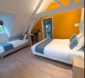 a bedroom with two beds and an orange wall at Maison Des Augustines in Saint-Amand-les-Eaux +23 photos
