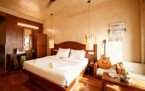ein Schlafzimmer mit einem Bett und einer Gitarre darin in der Unterkunft Monkey Tribe Munnar in Munnar + 16 Fotos