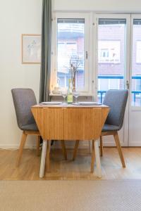 einem Esstisch mit 2 Stühlen und einem Fenster in der Unterkunft Rainbow Studio in Haga & Linné - Prime Location in Göteborg + 26 Fotos
