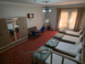 a hotel room with two beds and a desk at SaraSofi Hotel in Baku