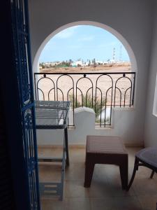 a room with a large window and a table and bench at tagermess 1 in Midoun