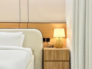 een slaapkamer met een bed en een lamp op een nachtkastje bij استديو بصالة طعام ومطبخ بجوار برج المملكة Tv 65 in Riyad
