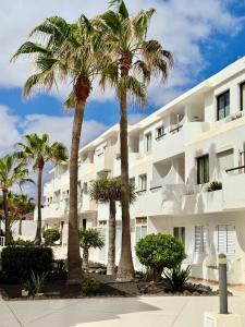 a group of palm trees in front of a building at Elixir Estate in Antigua