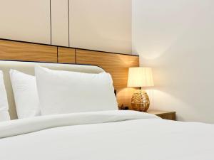 een slaapkamer met een wit bed en een lamp bij استديو بصالة طعام ومطبخ بجوار برج المملكة Tv 65 in Riyad