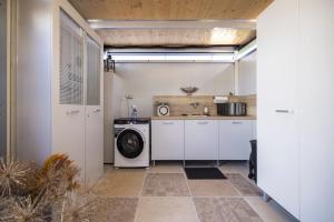 a kitchen with a washing machine and a sink at Finy Homes Stegersbach in Stegersbach