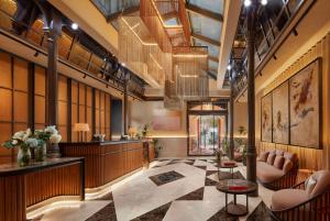 a lobby with chairs and a reception desk in a building at NH Collection Madrid Palacio de Tepa in Madrid +78 photos