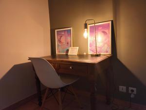 Un escritorio con una lámpara y una silla en una habitación. en Chambre spacieuse avec bureau et balcon, en Millas