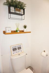 a bathroom with a toilet with a newspaper on top of it at La Ferme de la Bergerie 