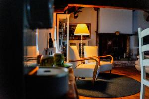 a living room with white chairs and a lamp at Villa Nides in Stazzona