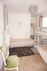 a bedroom with a bunk bed and a chair and a lamp at La Ferme de la Bergerie 