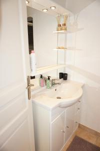 a white bathroom with a sink and a mirror at La Ferme de la Bergerie  +14 photos