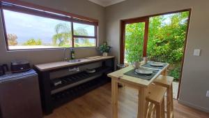 cocina con fregadero, mesa y ventana en The Royal Hilltop, en Riebeek-Kasteel