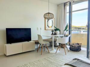 a living room with a tv and a table and chairs at Studio Lumare-Inn in Bergen aan Zee