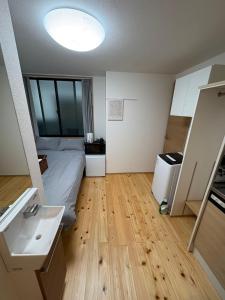 a bedroom with a bed and a sink and a bathroom at 新宿区の新築木造アパート-駅から徒歩5分 in Tokyo