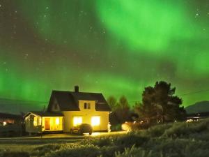 a house under the aurora in the sky at 6 person holiday home in Storsteinnes in Storsteinnes