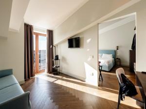 a living room with a couch and a bed and a mirror at Hotel Carlton in Treviso