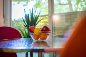 a bowl of fruit sitting on a table at Le Mérignac Cozy Corner - T3 & Terrasse in Mérignac