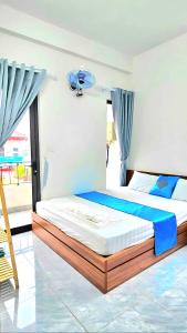 a bedroom with a large bed with blue curtains at Lộc Phát hotel Mộc Châu in Bả Duộc