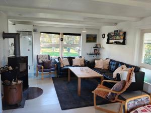 Una sala de estar con un sofá y una estufa de leña. en Cottage in scenic Langø, en Martofte 2 fotos más