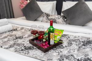 a table with two glasses and a bottle of wine at Private Cinema Apartment By Buddies Home in Greater Noida