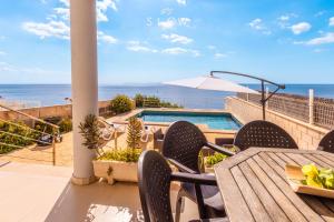 a patio with a table and chairs and the ocean at Villa Es Bufedo by Slow Villas in Cala Pi