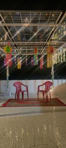 Dos bancos en una habitación con cometas colgando del techo. en Rama Ashish, en Ābu Road