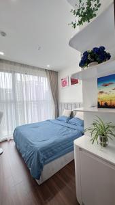 a bedroom with a bed with a blue bedspread at Masteri Pearl Apartment - Luxury view in Ocean Park 1 in Gia Lâm Pho +21 photos