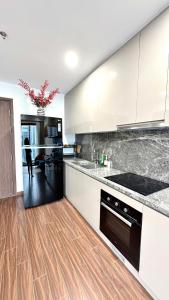 a kitchen with white cabinets and a wooden floor at Masteri Pearl Apartment - Luxury view in Ocean Park 1 in Gia Lâm Pho