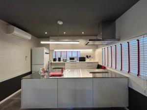 a kitchen with a large island in the middle of it at アフリカンラグジュアリースタイルの豪華客室 1棟貸切 バーベキュー 大人数対応 ファミーユ大室 in Ito +29 photos