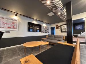 a living room with a couch and a table at アフリカンラグジュアリースタイルの豪華客室 1棟貸切 バーベキュー 大人数対応 ファミーユ大室 in Ito