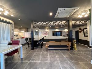 a living room with a couch and a table at アフリカンラグジュアリースタイルの豪華客室 1棟貸切 バーベキュー 大人数対応 ファミーユ大室 in Ito