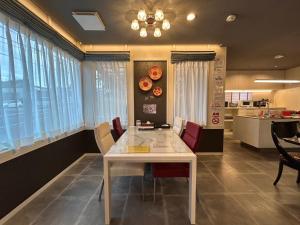 a dining room with a white table and chairs at アフリカンラグジュアリースタイルの豪華客室 1棟貸切 バーベキュー 大人数対応 ファミーユ大室 in Ito