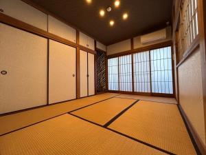 an empty room with doors and windows and a room with mats at アフリカンラグジュアリースタイルの豪華客室 1棟貸切 バーベキュー 大人数対応 ファミーユ大室 in Ito