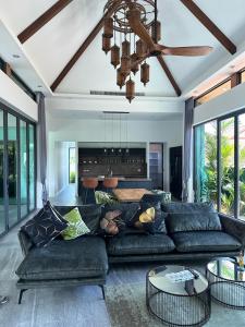 un salon avec un canapé et un ventilateur de plafond dans l'établissement Luxury Pool Villa Near Laguna - Gym, Jacuzzi & Cinema, à Phuket